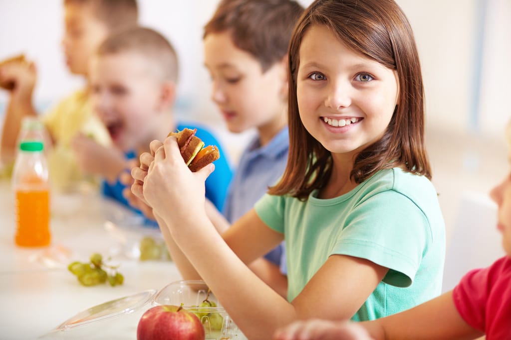 Smiling girl eating sandwich image