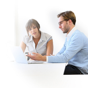 2 workers in front of a computer displaying leadership qualities