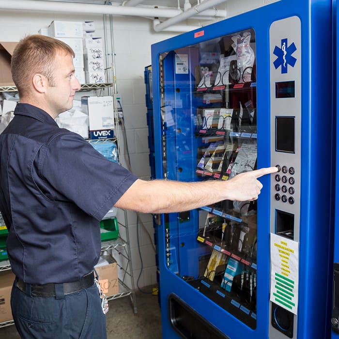 Image of emt professional interacting with ems and pharmaceutical vending machine