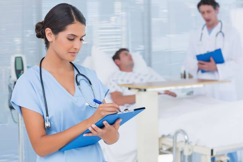 Image of Female medical professional taking notes in hospital room